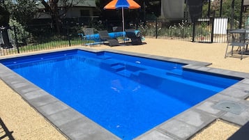 Een seizoensgebonden buitenzwembad, parasols voor strand/zwembad