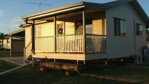 A single-story mobile home with a porch, a chimney, and a small attached garage. - Lee Farm Stay Cottages (Booie)
