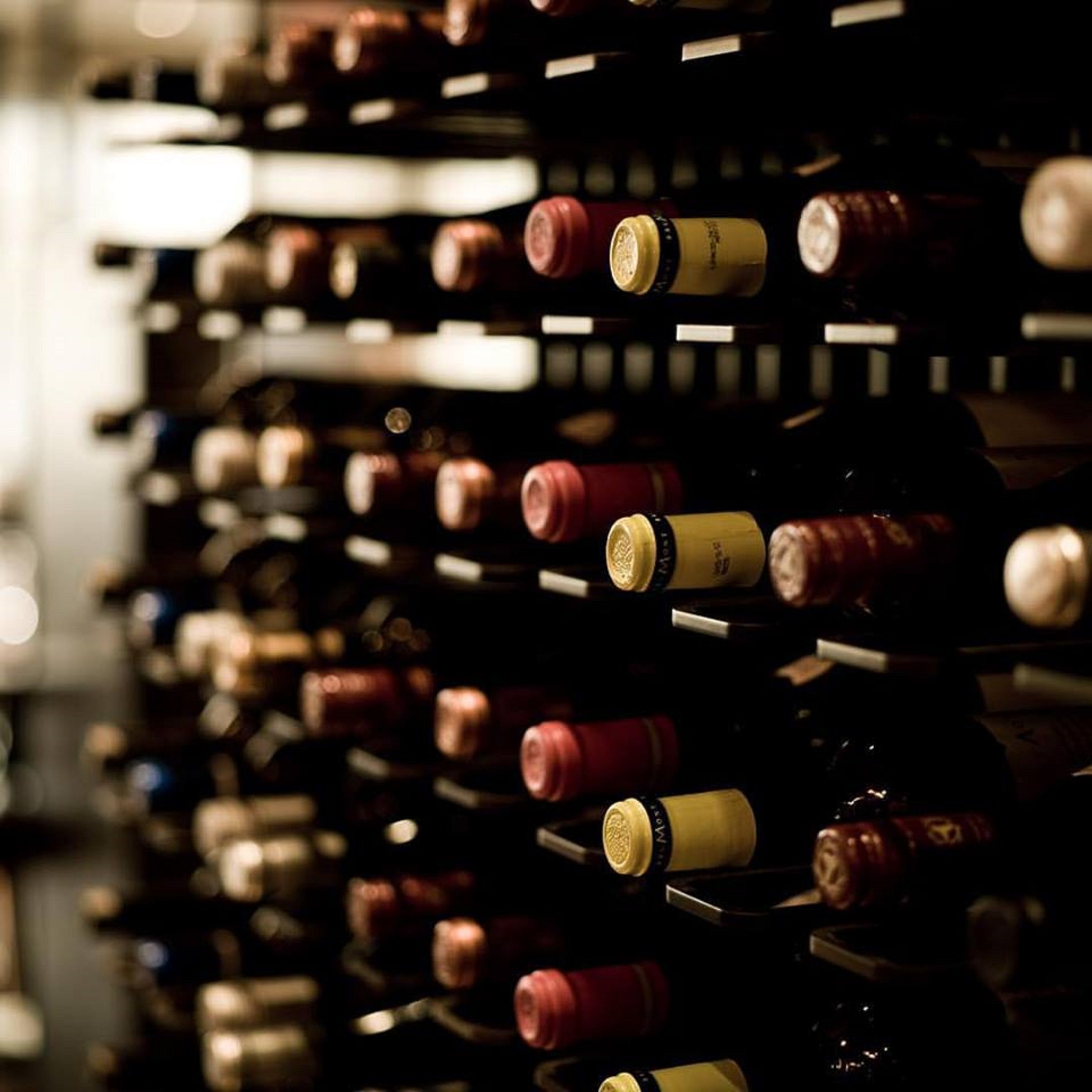 Una bodega con hileras de botellas de vino.