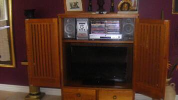 A wooden entertainment center with a television, speakers, and a CD player.