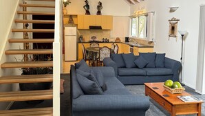 Een moderne woonkamer met een trap, een eethoek en een keuken.