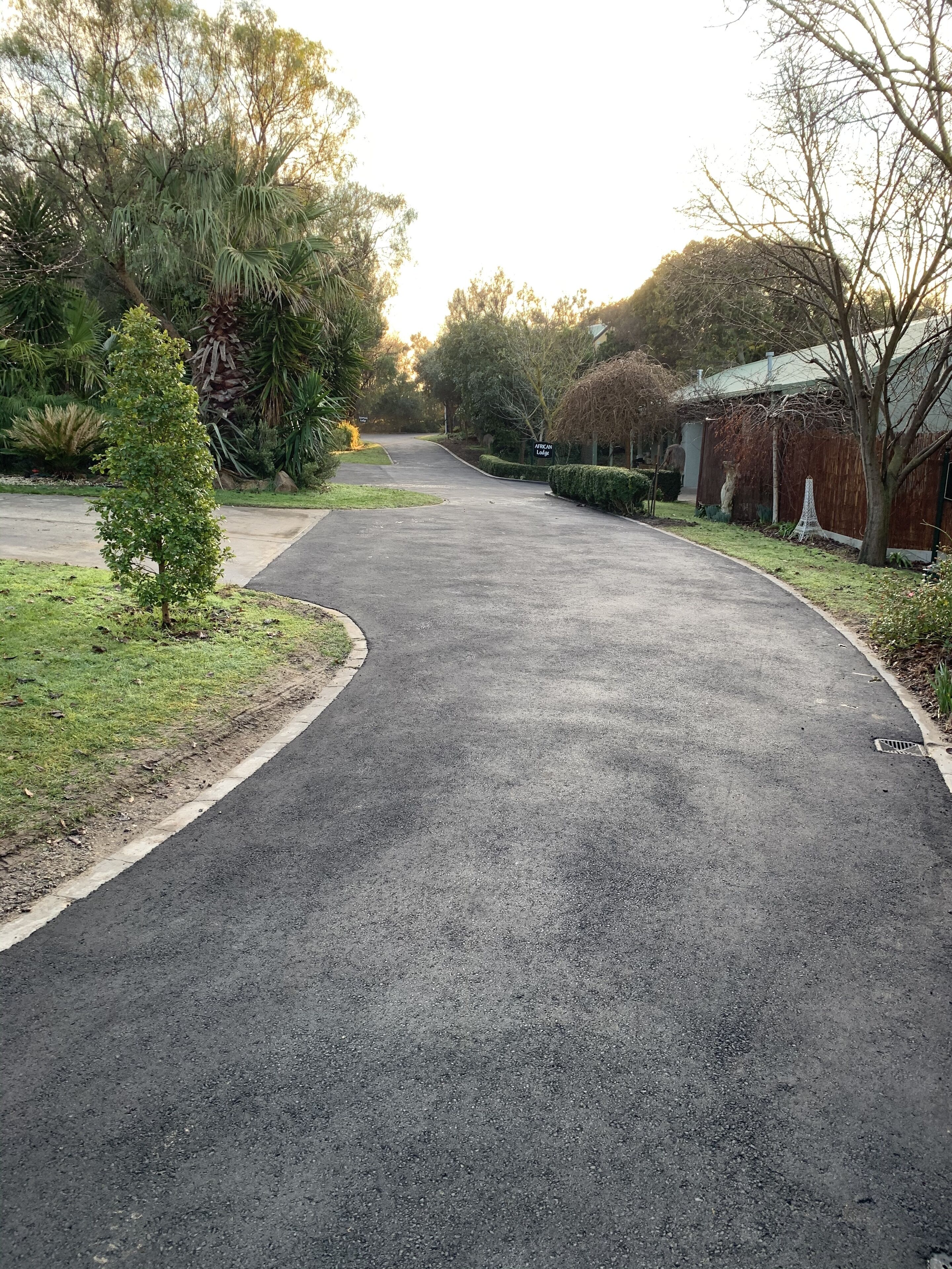 A curved driveway leading to a building with a sign that reads "American Lodge."