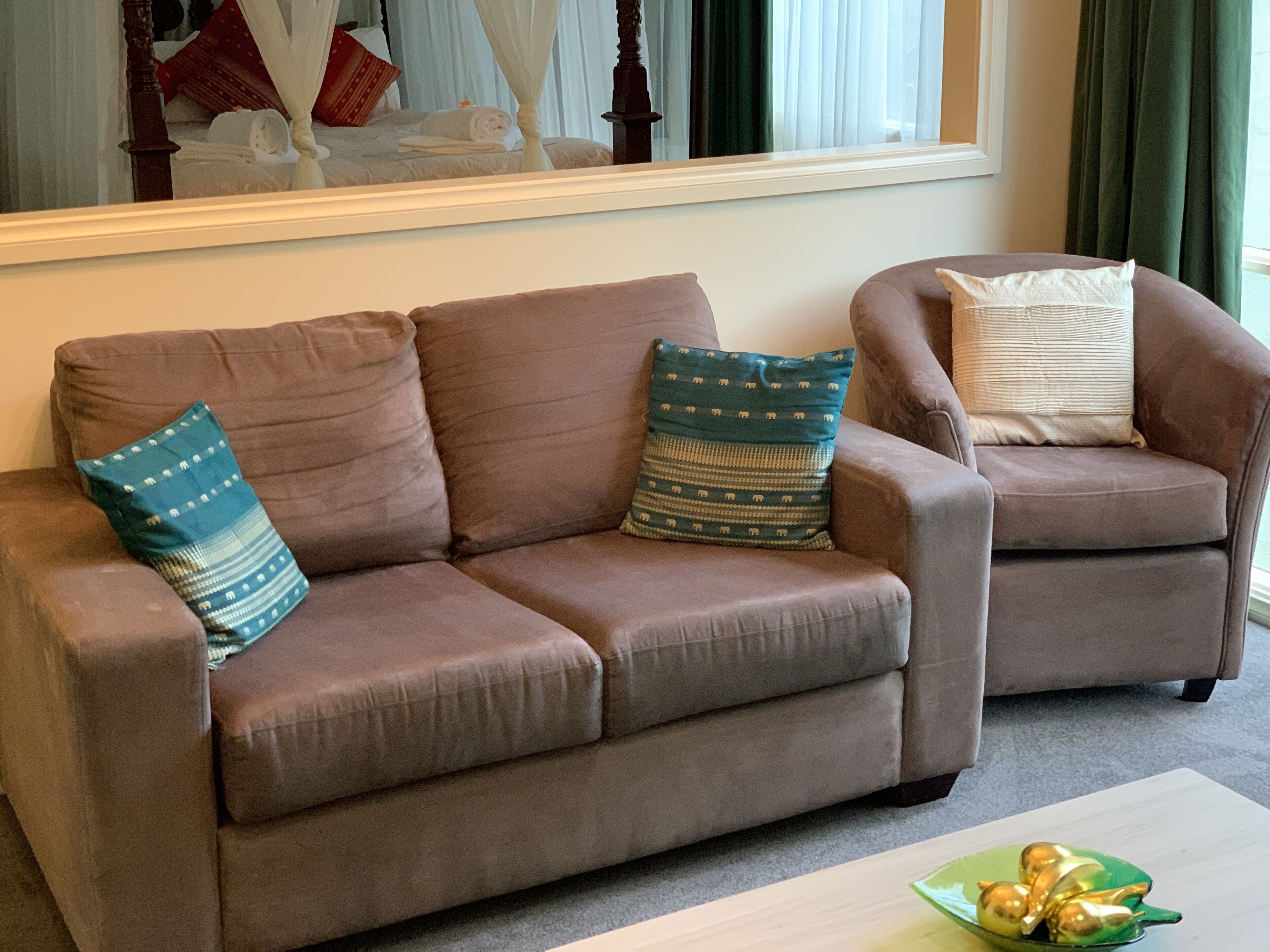 A living room with a brown sofa, two armchairs, and a coffee table.