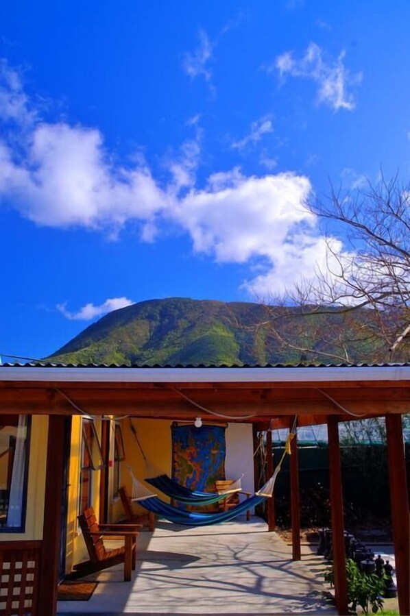 A wooden structure with a hammock and chairs, a map on the wall, and a view of a mountain. - Sequoia Lodge & Backpackers (Picton)
