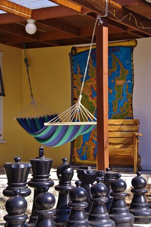 A chessboard with black pieces, a hanging hammock, and a colorful map on the wall. - Sequoia Lodge & Backpackers (Picton)