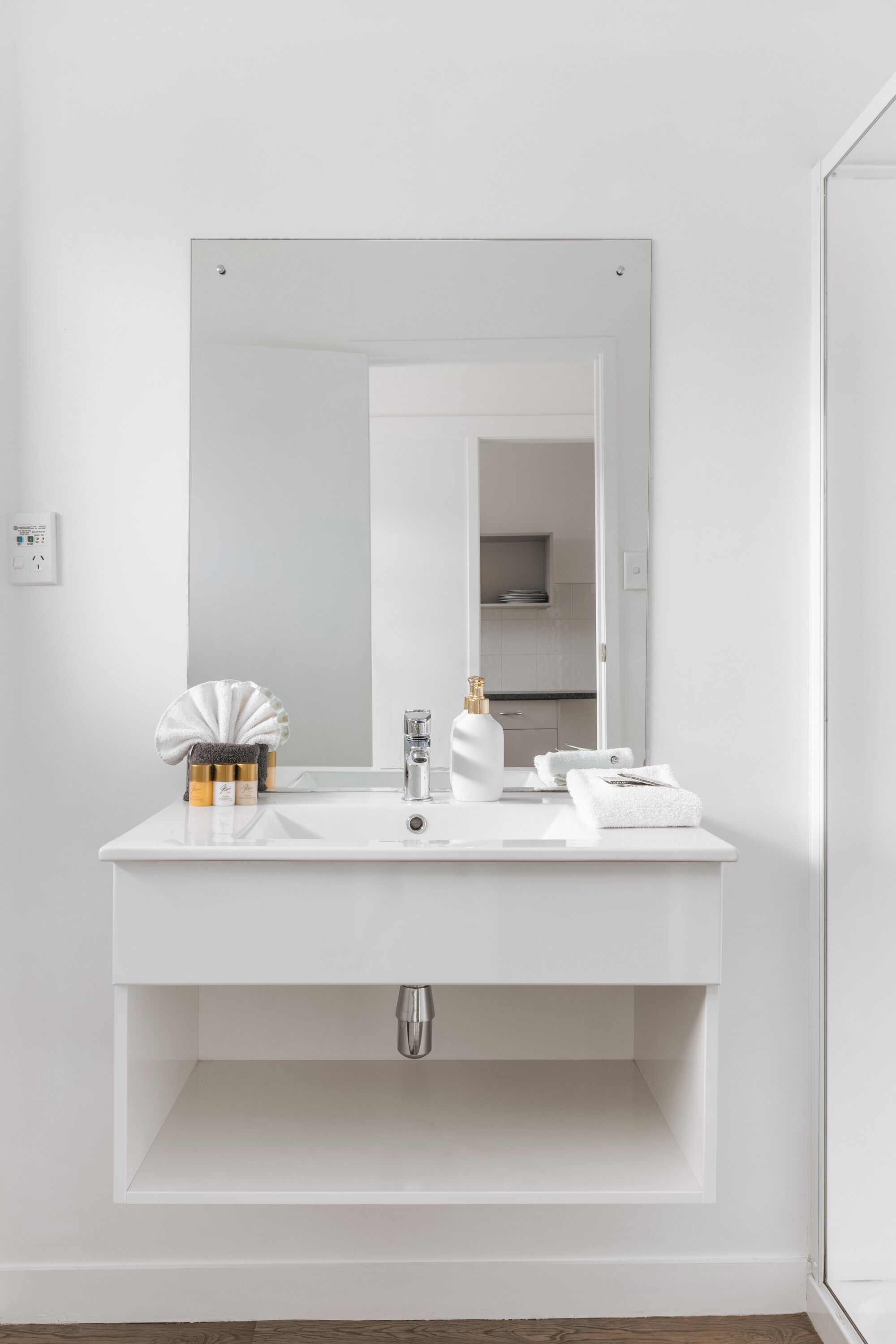 Une salle de bain moderne avec un meuble-lavabo blanc, un grand miroir et un évier.