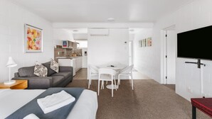 A hotel room with a bed, a desk, a sofa, and a TV. - Avalon Motel Thames – Wenzel Motels (Thames)