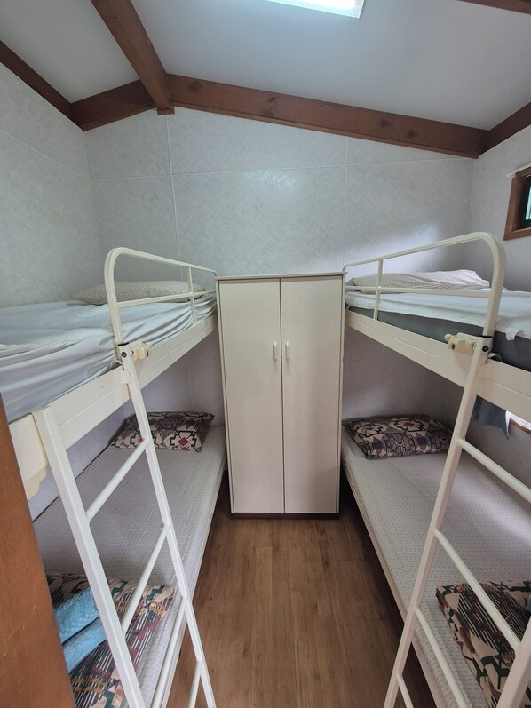 Una habitación con literas, un armario y una ventana.