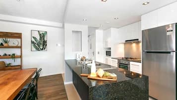 Una cocina moderna con una isla central, electrodomésticos de acero inoxidable y una mesa de comedor de madera.