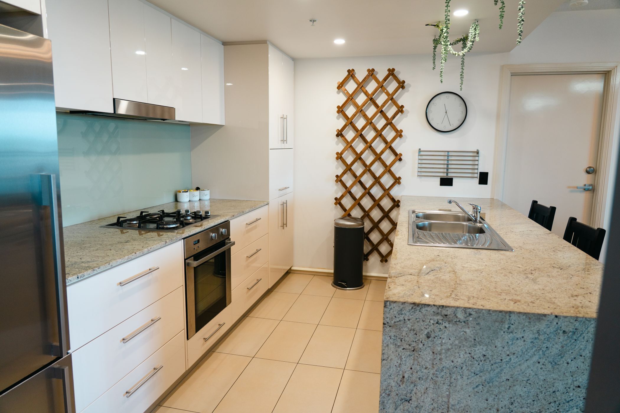 A modern kitchen with white cabinets, a stainless steel range, and a granite countertop.