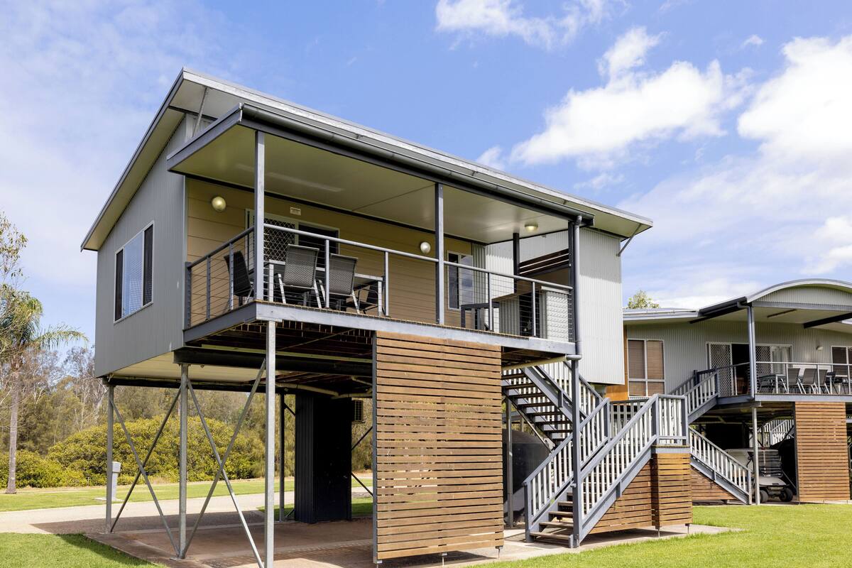A modern two-story building with a balcony and a staircase leading to an upper level.