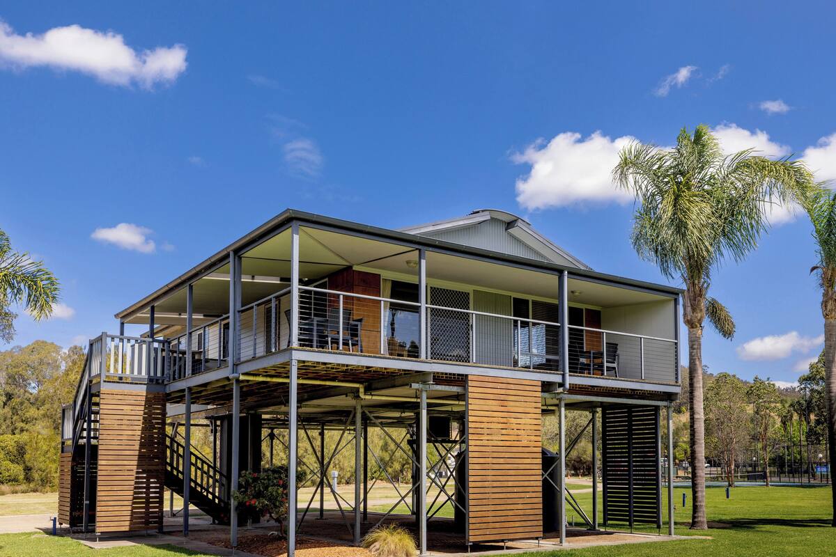 A two-story house with a balcony, a covered patio, and a staircase.