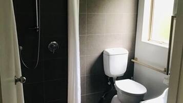 Un bagno piccolo e funzionale, con doccia, servizi igienici e lavandino.