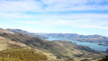 Una vista panoràmica d'un paisatge de muntanyes amb un llac i turons a la distància.