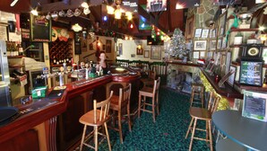 A bar area with wooden bar counters, chairs, and a Christmas tree. - Darcy Arms Motel (Surfers Paradise)
