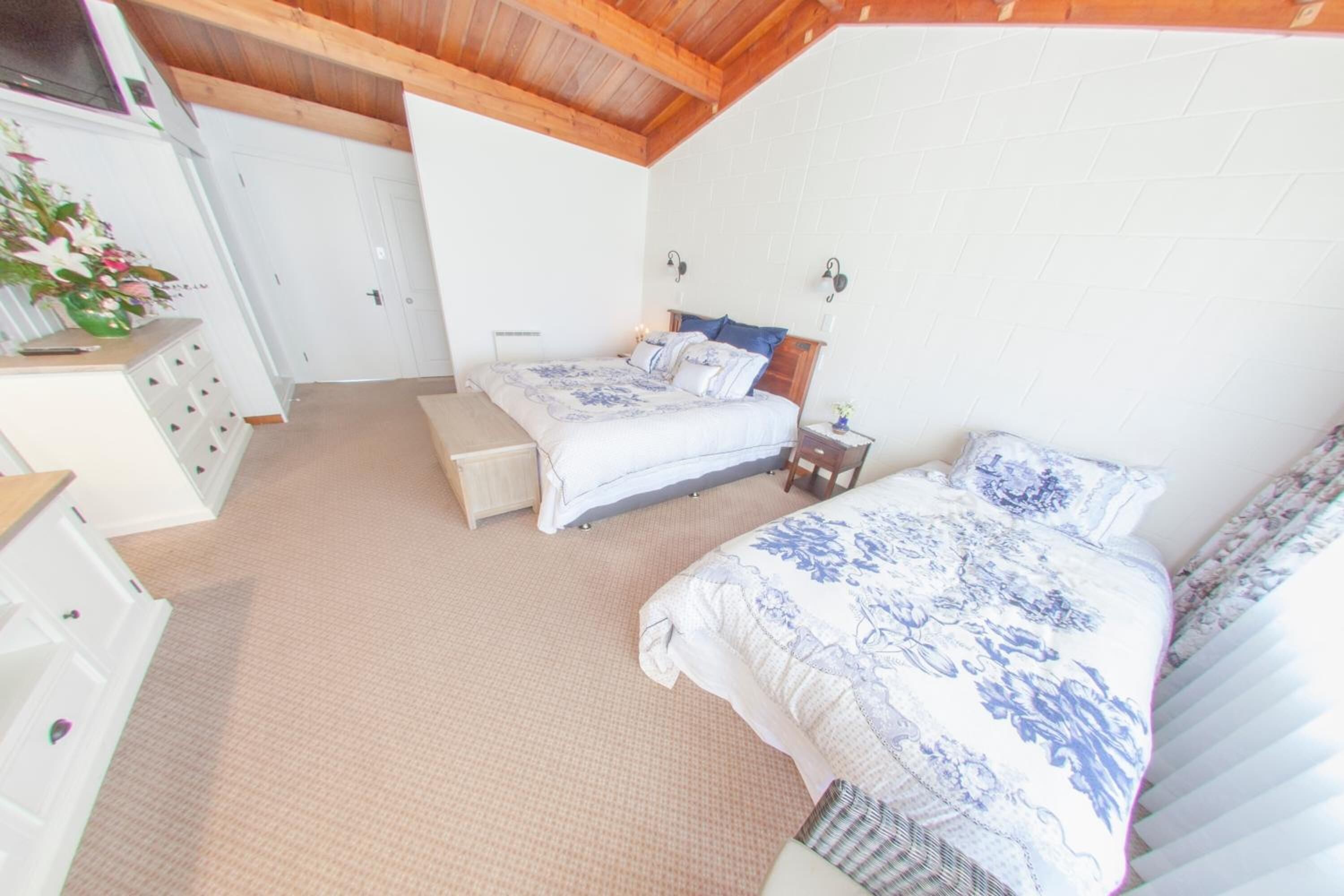 Un dormitorio con dos camas, un aparador y un radiador.