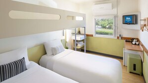 A hotel room with two beds, a TV, a window with a view, a sink, and a small kitchenette. - Ibis Budget Newcastle (Wallsend)