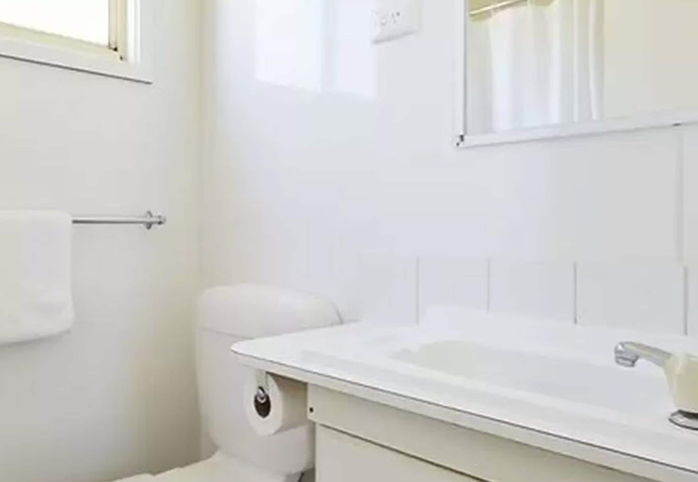 A bathroom with a white sink, toilet, and towel rack.