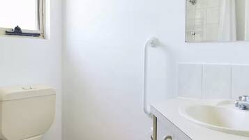 Ein Badezimmer mit Toilette, Waschbecken und Spiegel.