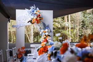 A wedding reception setup with a floral arch and a sign reading "Coral & Micheal".