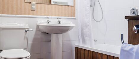 A bathroom with a toilet, sink, and shower.