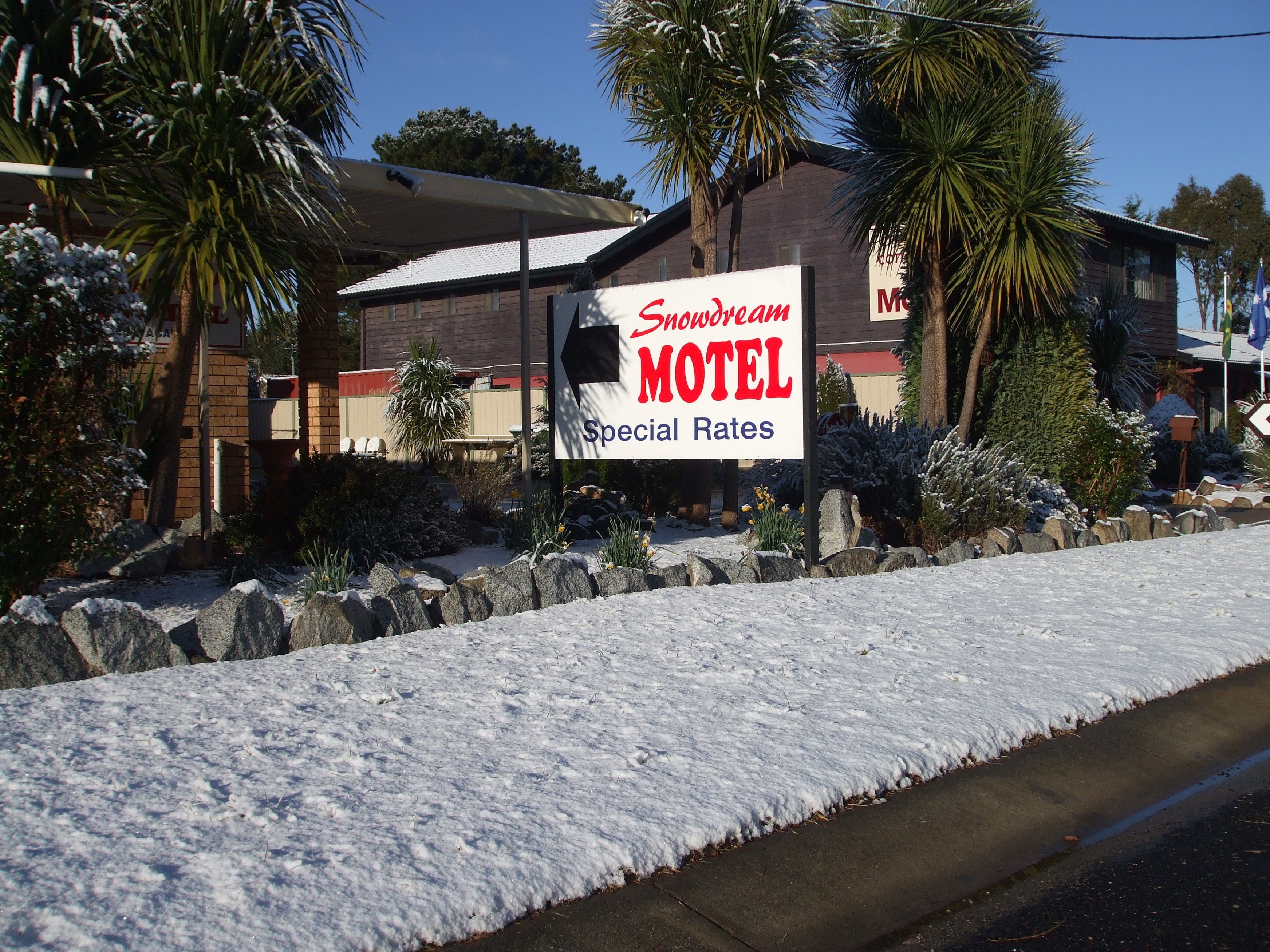 A motel sign with a snow-covered ground.