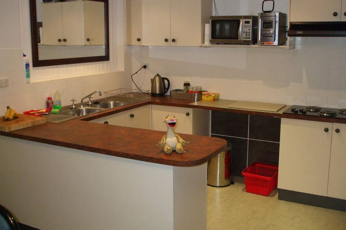 A kitchen with a wooden island, a sink, a microwave, and a stove.