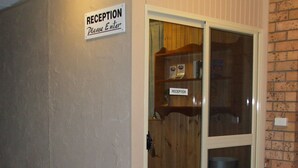 Un área de recepción con un cartel que dice 'RECEPTION Please Enter'.