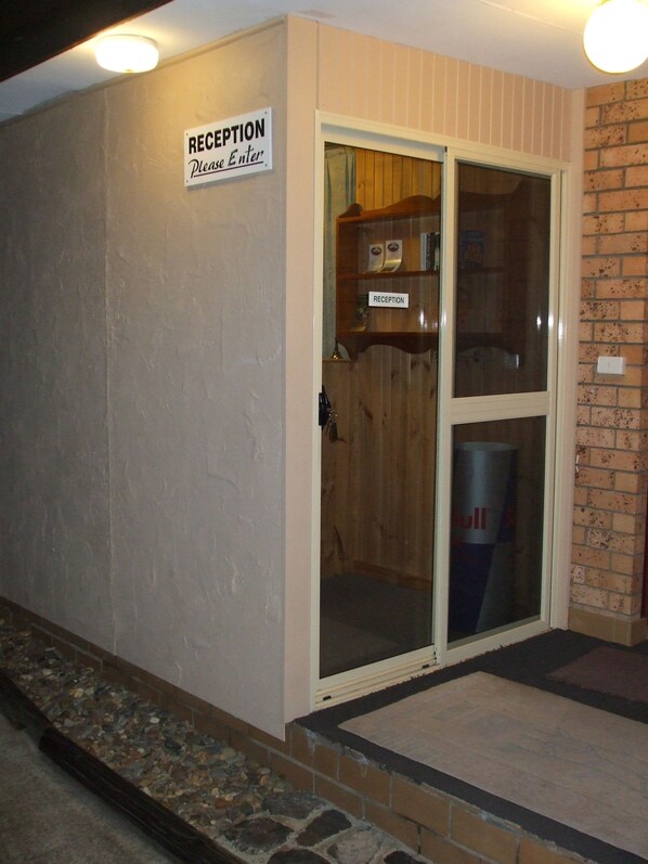 A reception area with a sign that reads "RECEPTION Please Enter."