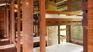 A wooden cabin with bunk beds and a sloped ceiling. - Paganakan Dii Tropical Retreat (Sandakan)
