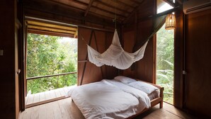 A wooden room with a bed, a window, and a hanging canopy. - Paganakan Dii Tropical Retreat (Sandakan)