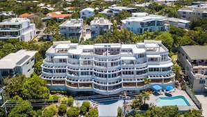 Un hôtel à plusieurs étages doté d’une piscine et d’un espace extérieur aménagé avec des sièges.