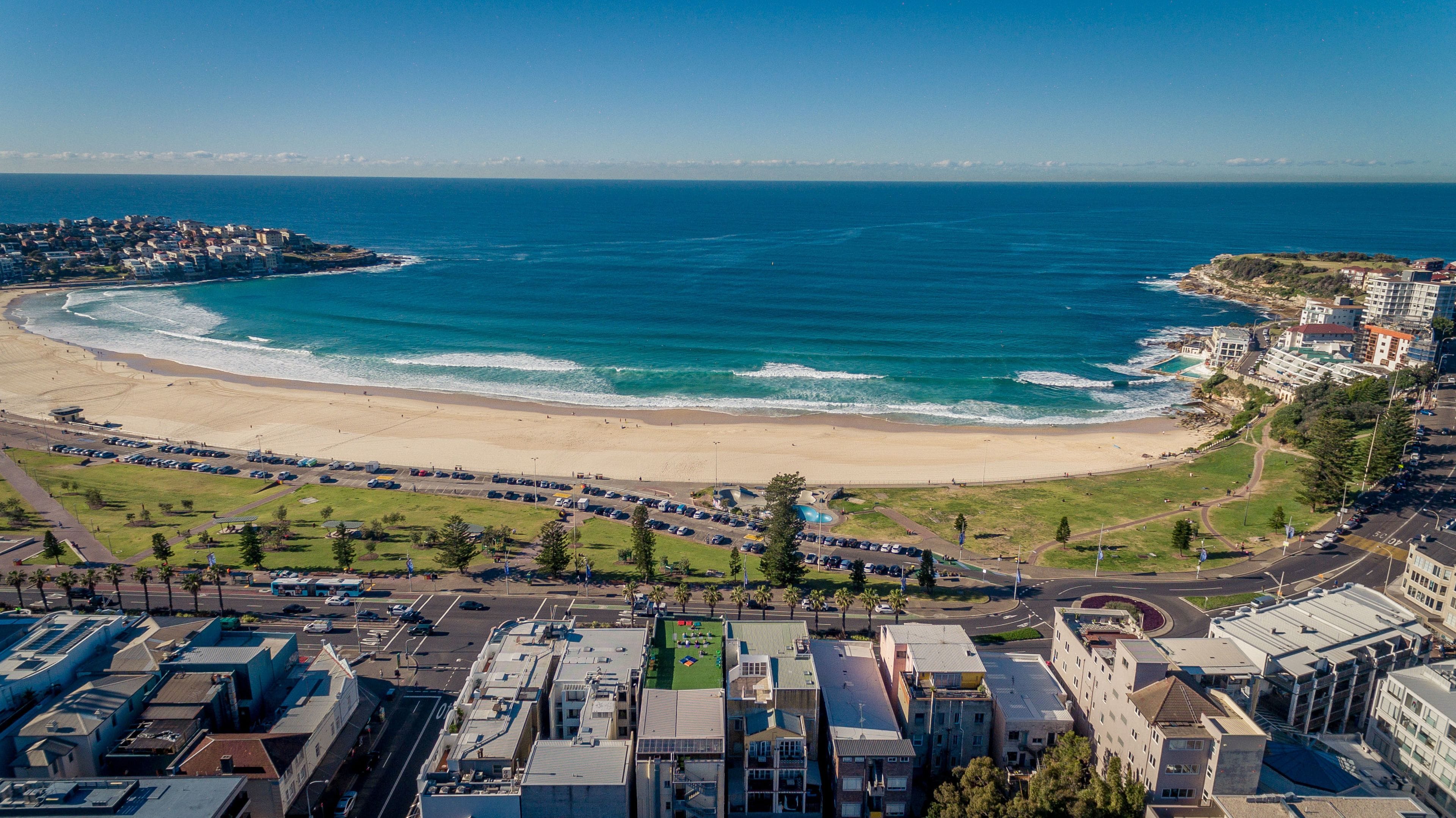 A coastal cityscape with a beach, buildings, and a clear sky.