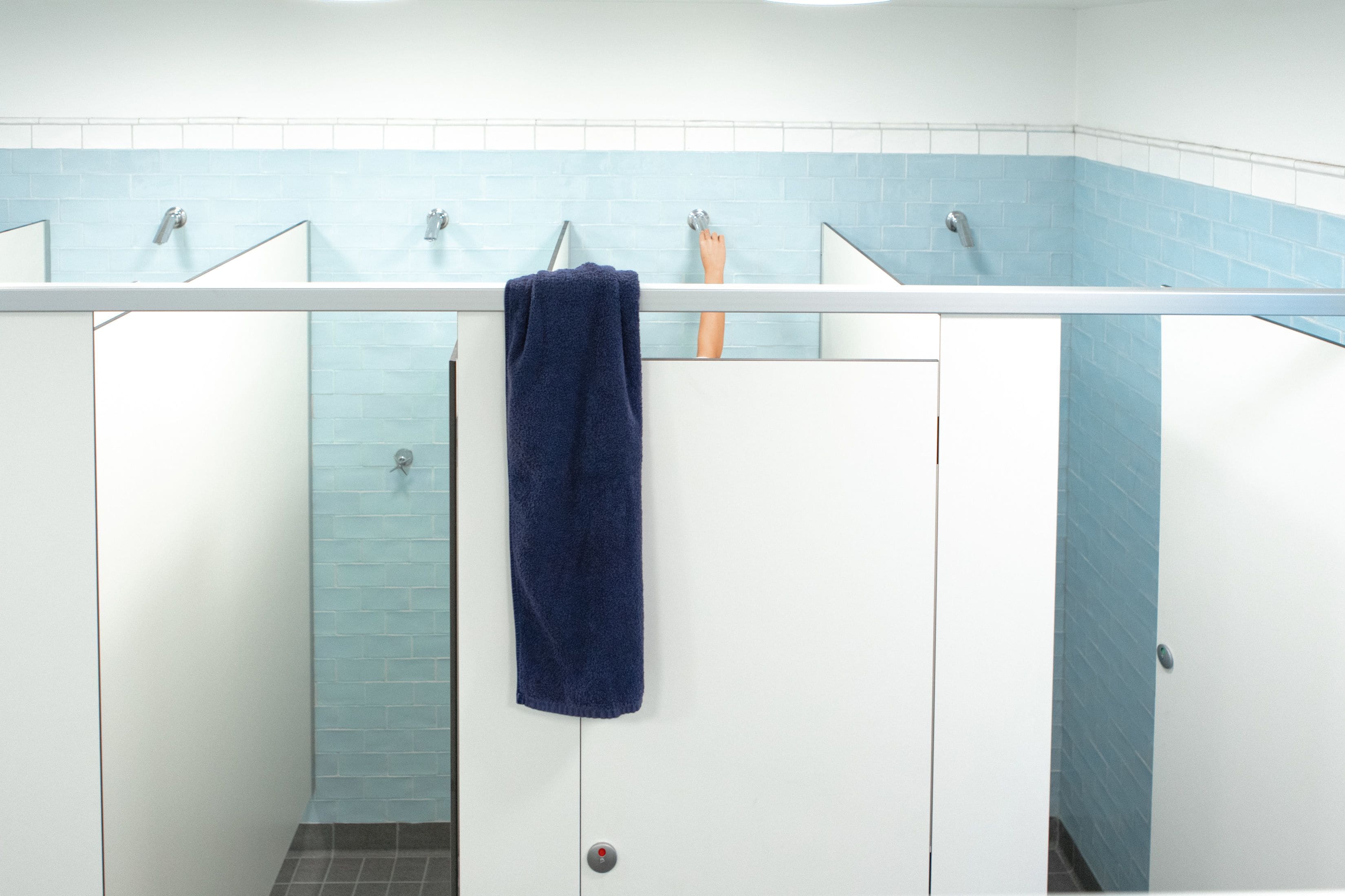 A public restroom with multiple sinks and a blue-tiled wall.