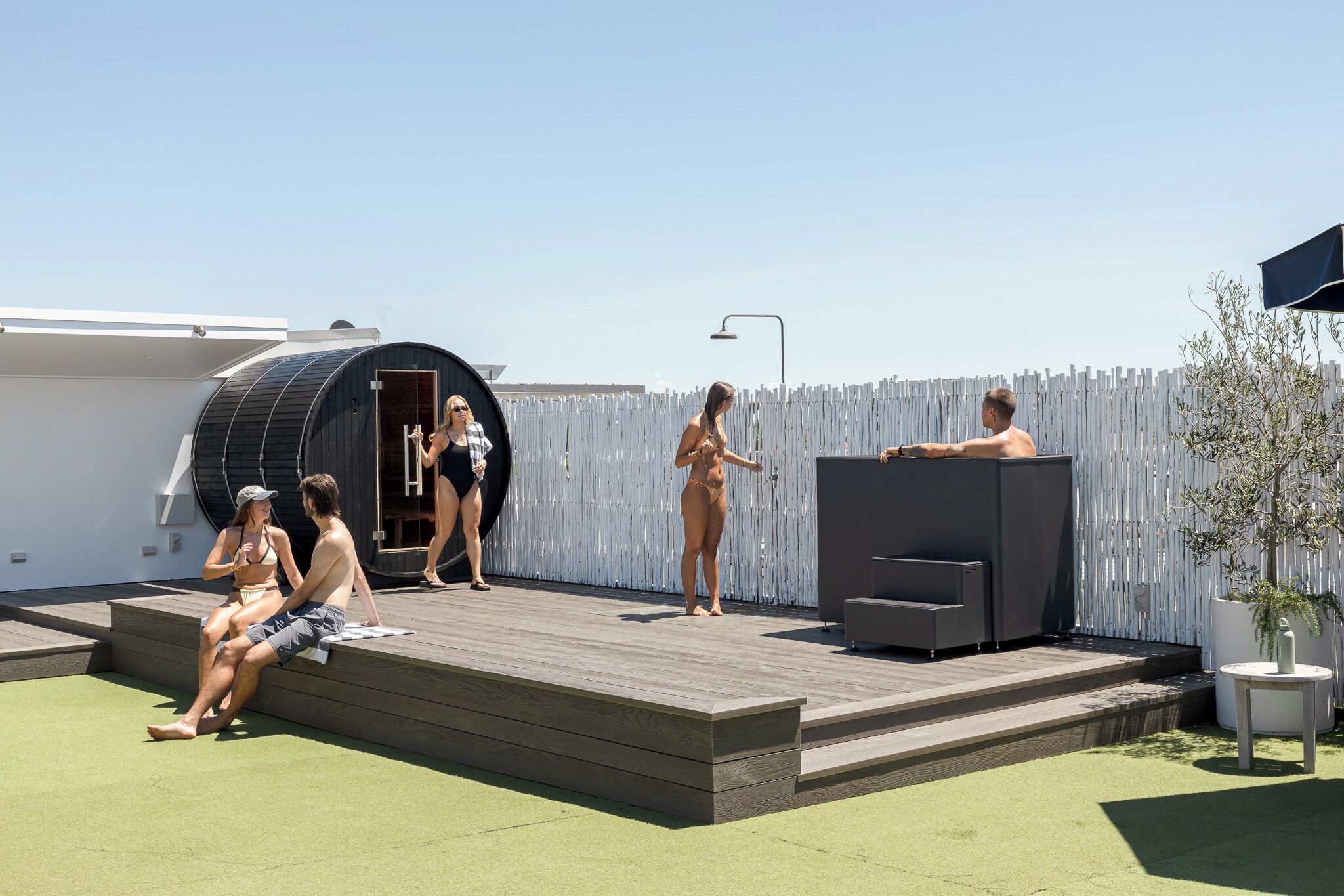 Terraza en la azotea con una estructura circular, mobiliario exterior y una planta en maceta.