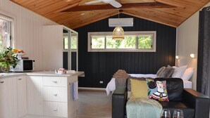 A cozy room with a bed, a dining area, and a kitchen.