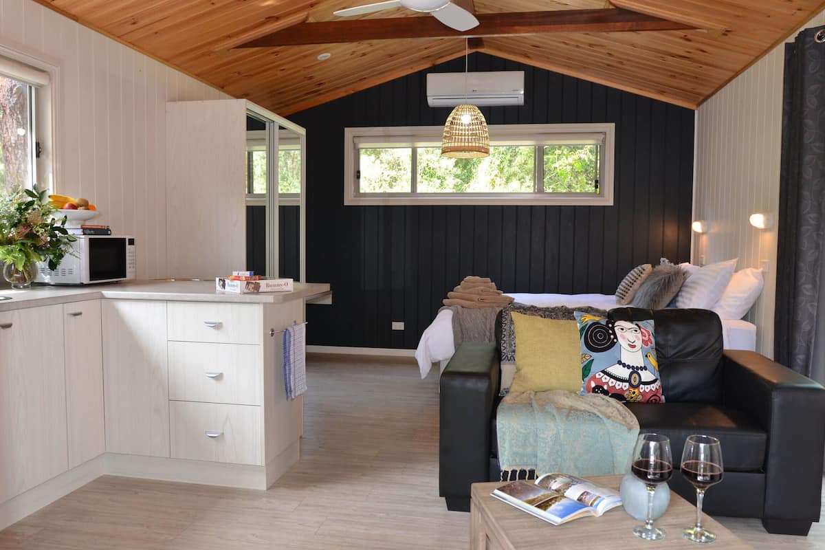 Una habitación acogedora con cama, comedor y cocina.