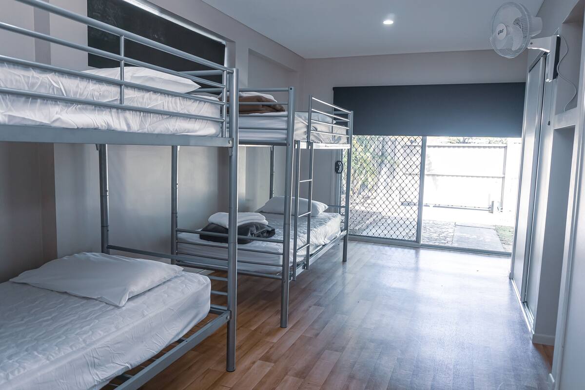 A bunk bed room with a sliding glass door leading to an outdoor area.