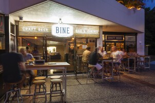 Un bar de cervezas artesanales y comedor con mesas al aire libre y una barra.