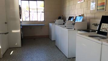 A laundry facility with multiple washing machines and a sink.