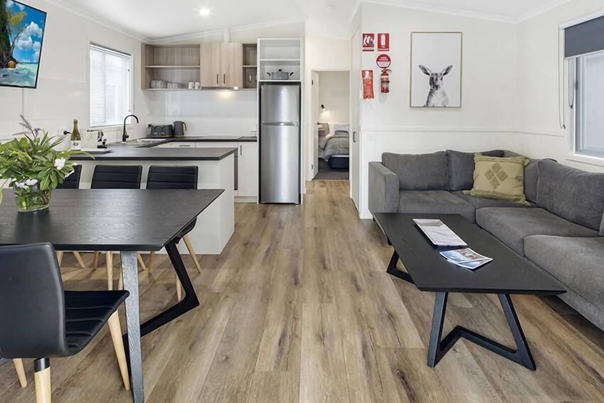 A modern apartment with a dining area, kitchen, and living room.