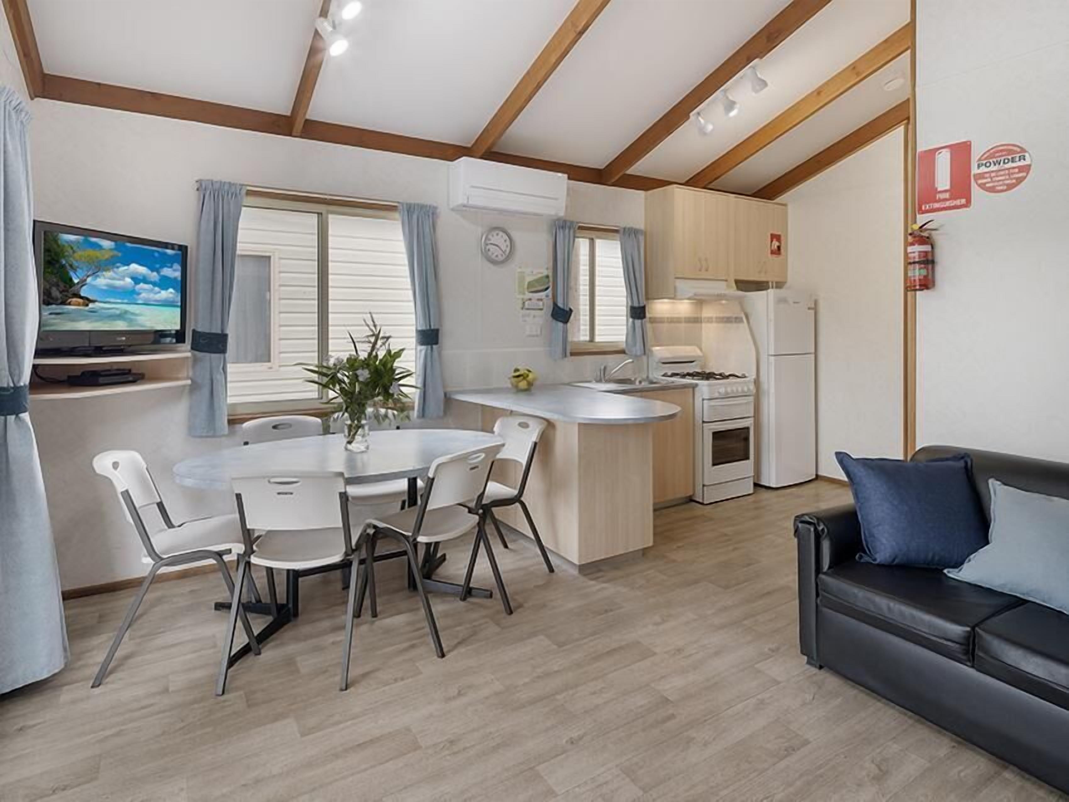 Un espace de vie compact comprenant un coin repas, une kitchenette et un canapé.
