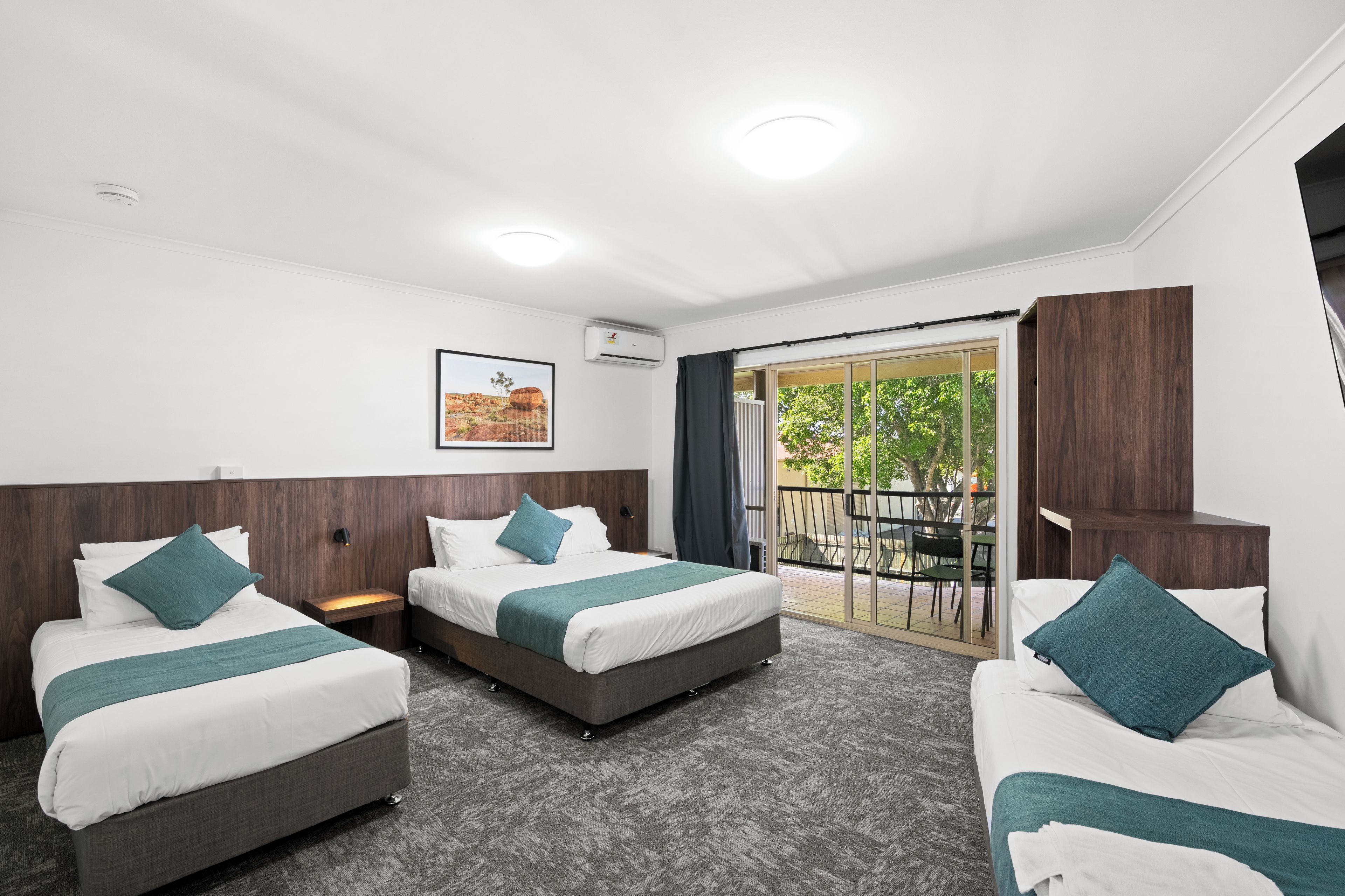 Habitación de hotel con dos camas, un ventanal grande y vistas al exterior.