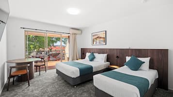 Una habitación de hotel con dos camas, un escritorio y una silla.