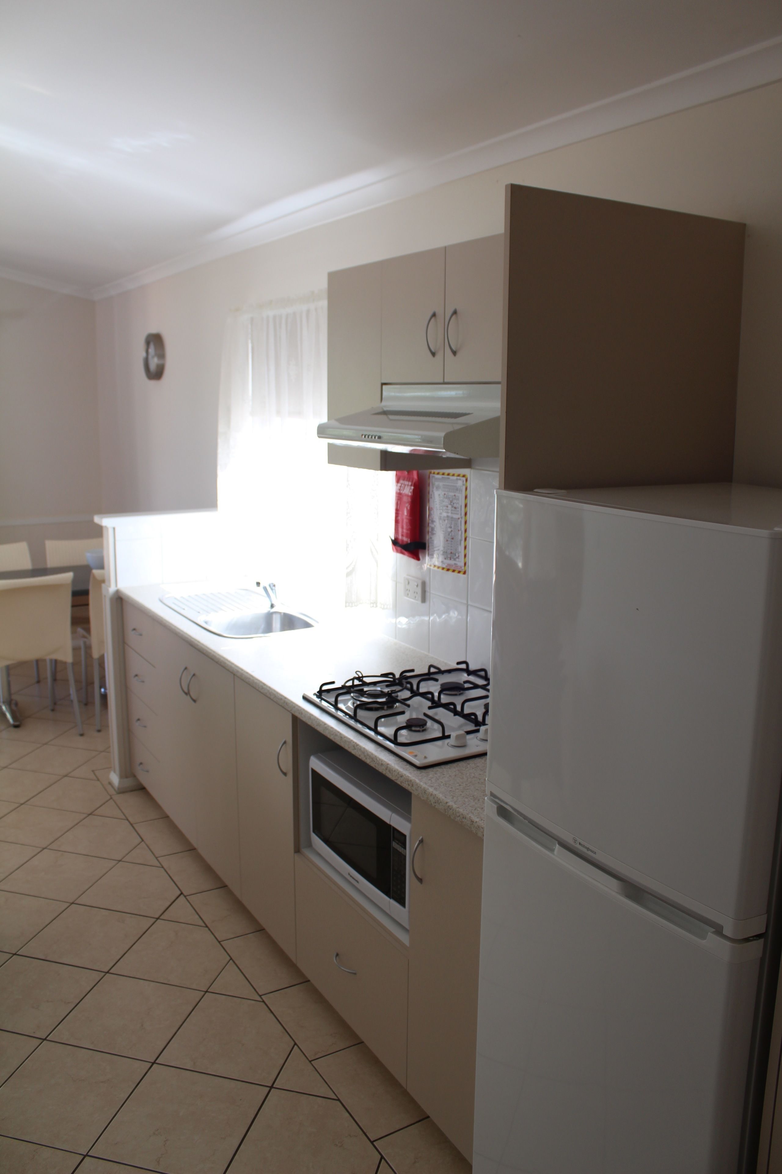 A compact kitchen with a gas stove, a sink, and a refrigerator.