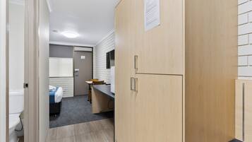 A compact hotel room with a bathroom, a kitchenette, and a small dining area.