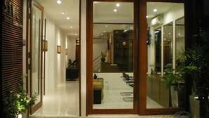 A modern hotel entrance with a glass door and a small outdoor seating area. - 5ive Beach House Hotel (Pattaya)