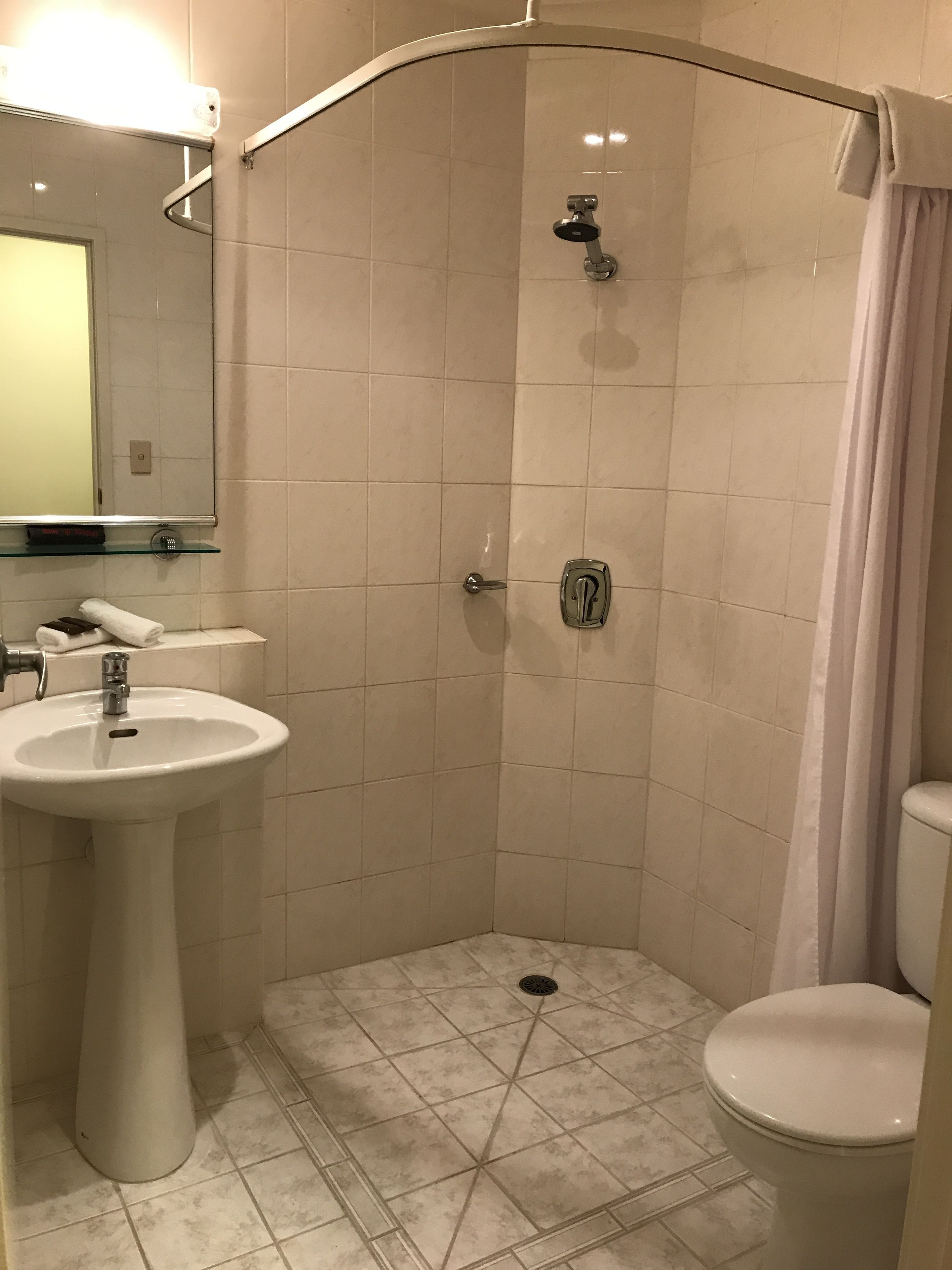 A bathroom with a shower, sink, and toilet.