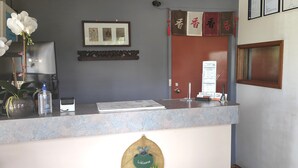 Una reception con un quadro incorniciato, una bacheca e un cartello di benvenuto.