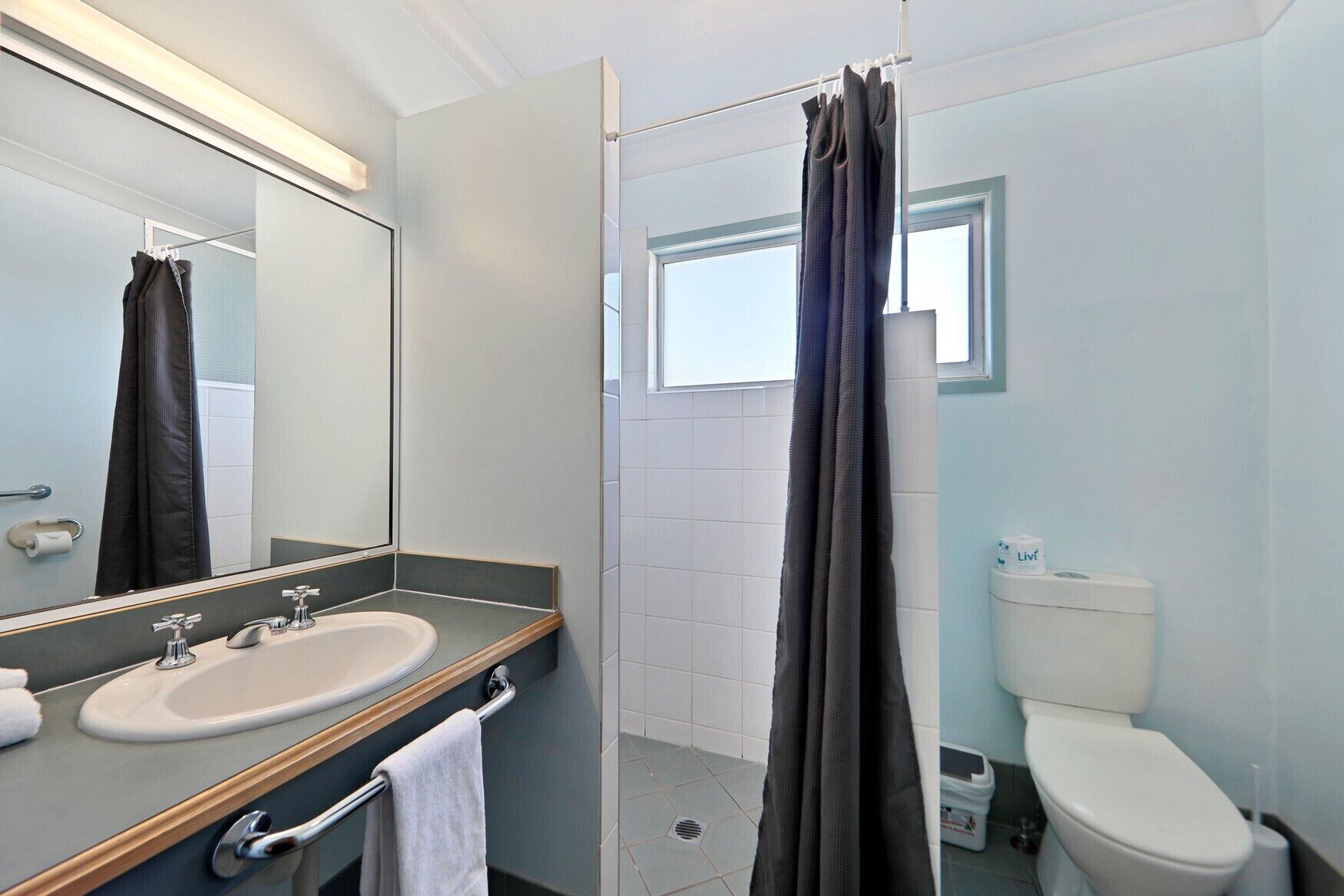 Un baño moderno con ducha, inodoro y lavamanos.